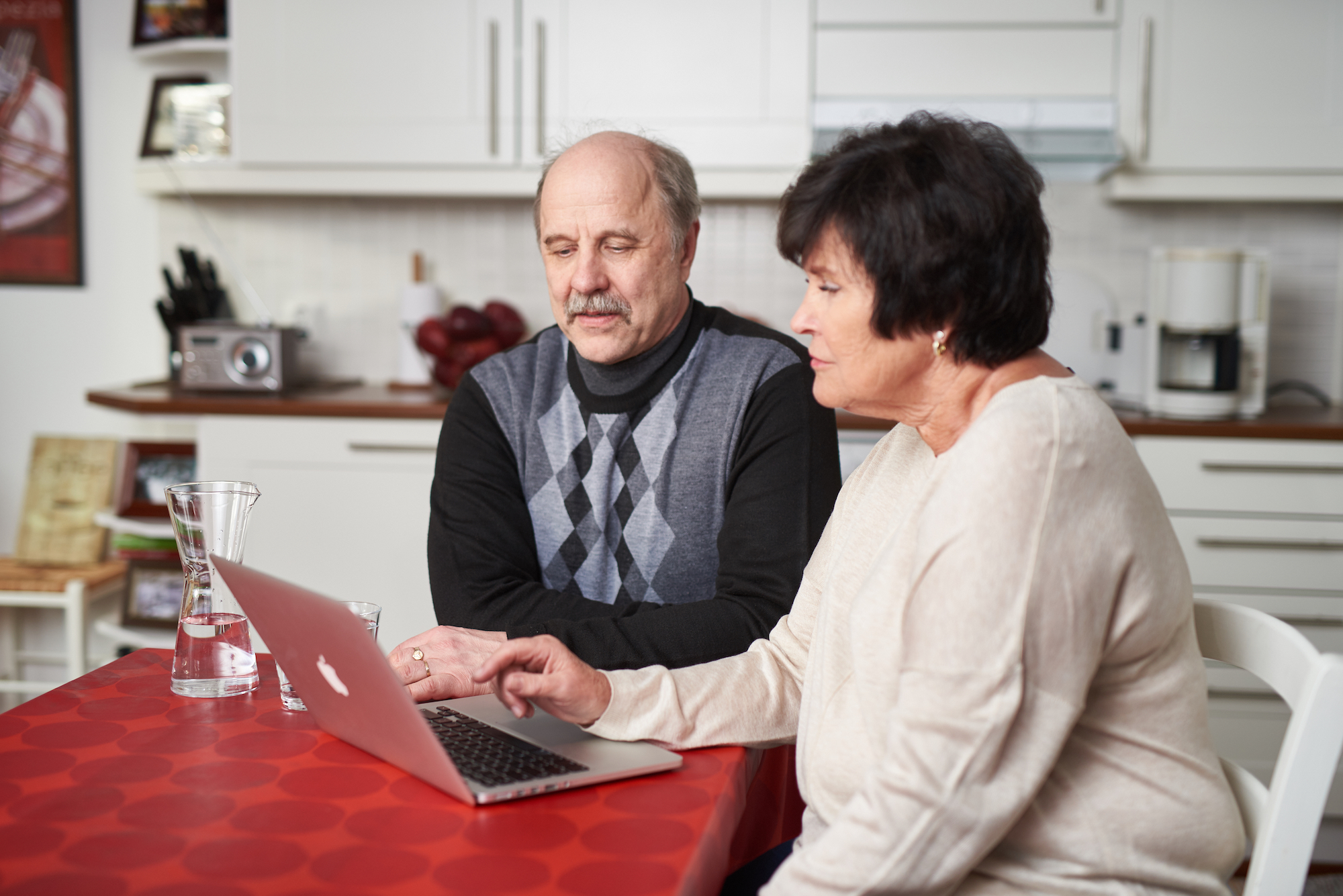Mies ja nainen selaavat kannettavaa tietokonetta