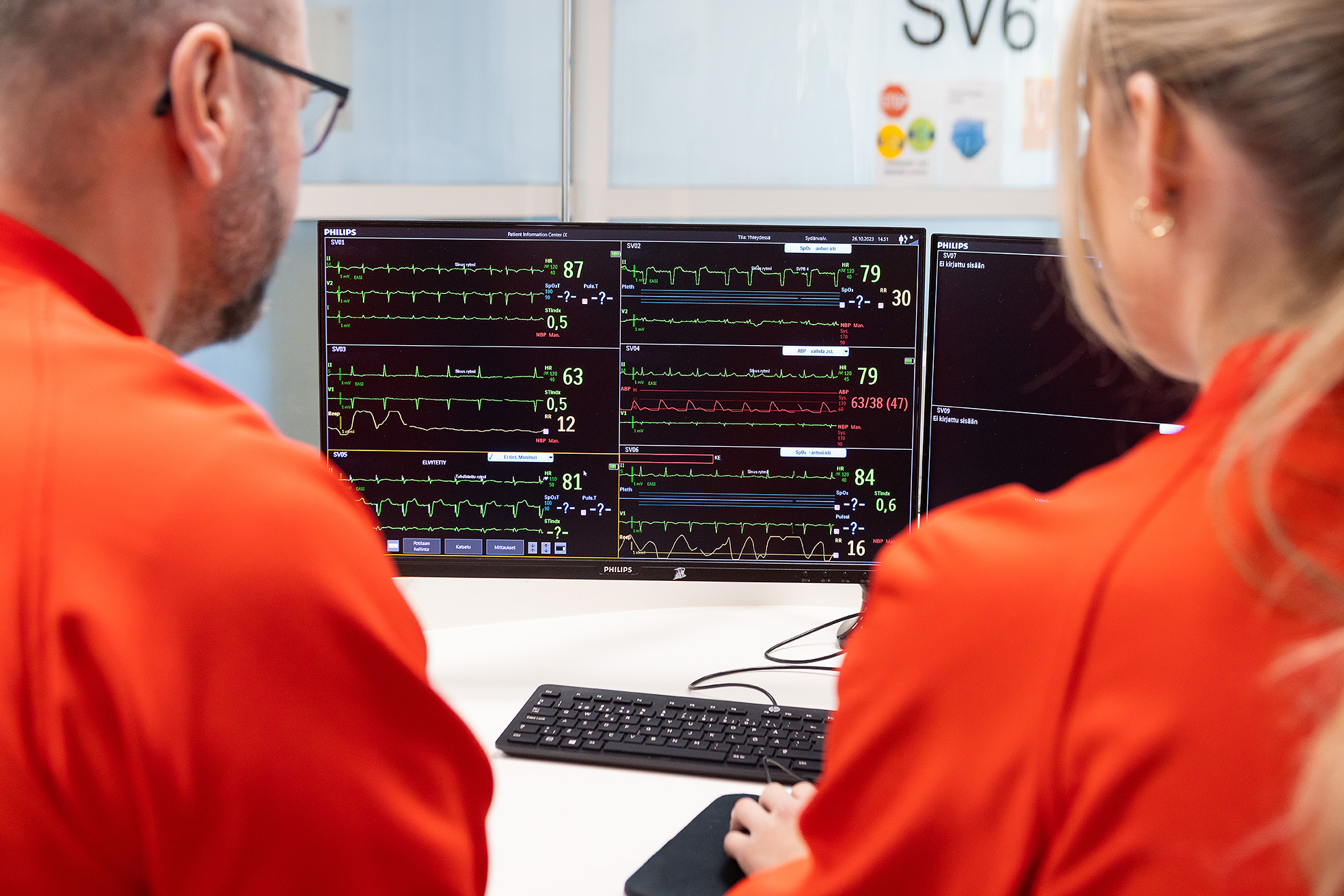 Hoitajat valvovat sydänpotilaiden tietoja tietokoneen näytöllä sydänvalvontaosastolla.
