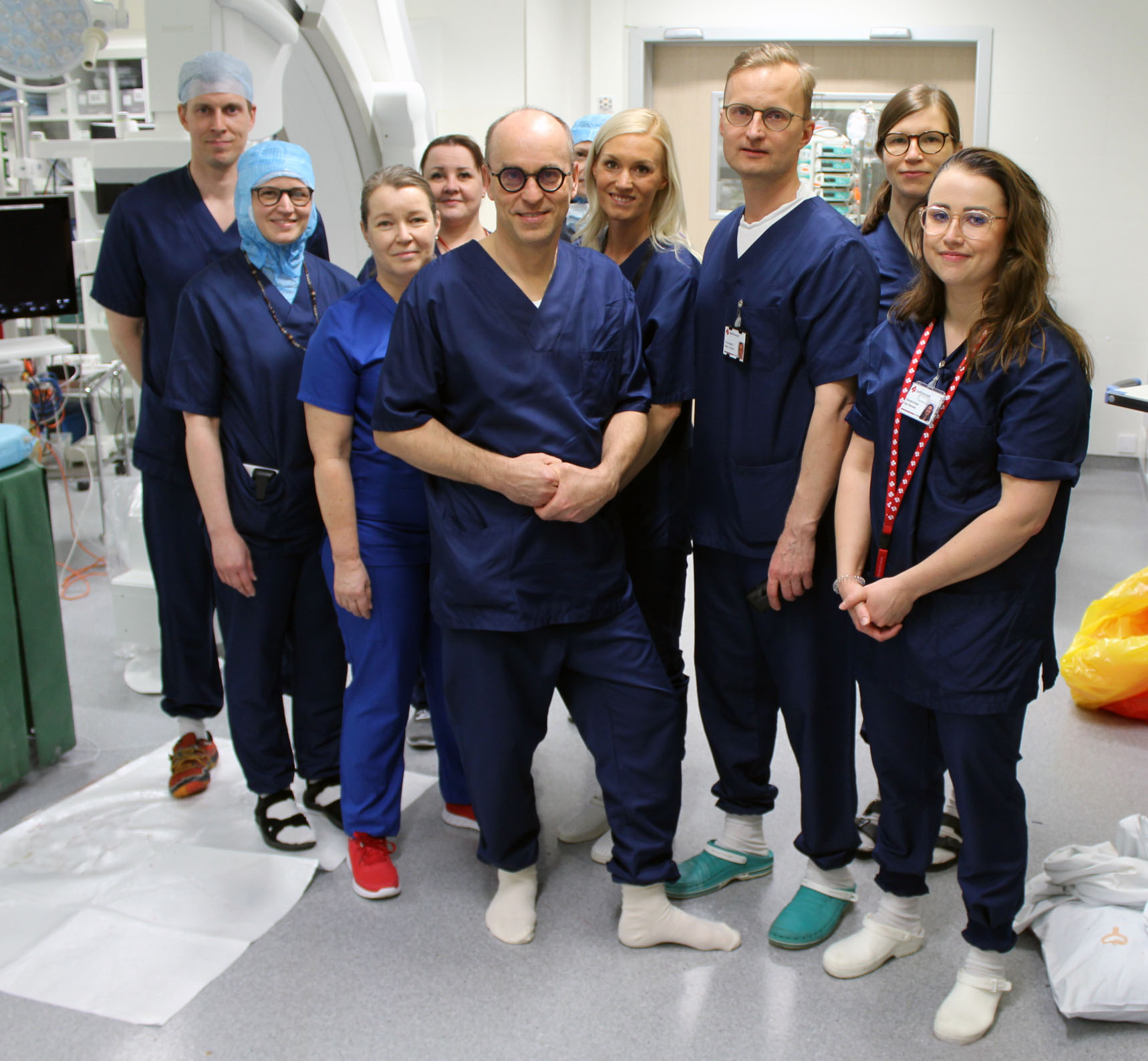 Lääkäreitä ja sairaanhoitajia seisoo ryhmässä sydäntoimenpidesalissa